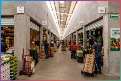 Pasillo del mercado con locales de frutas y verduras